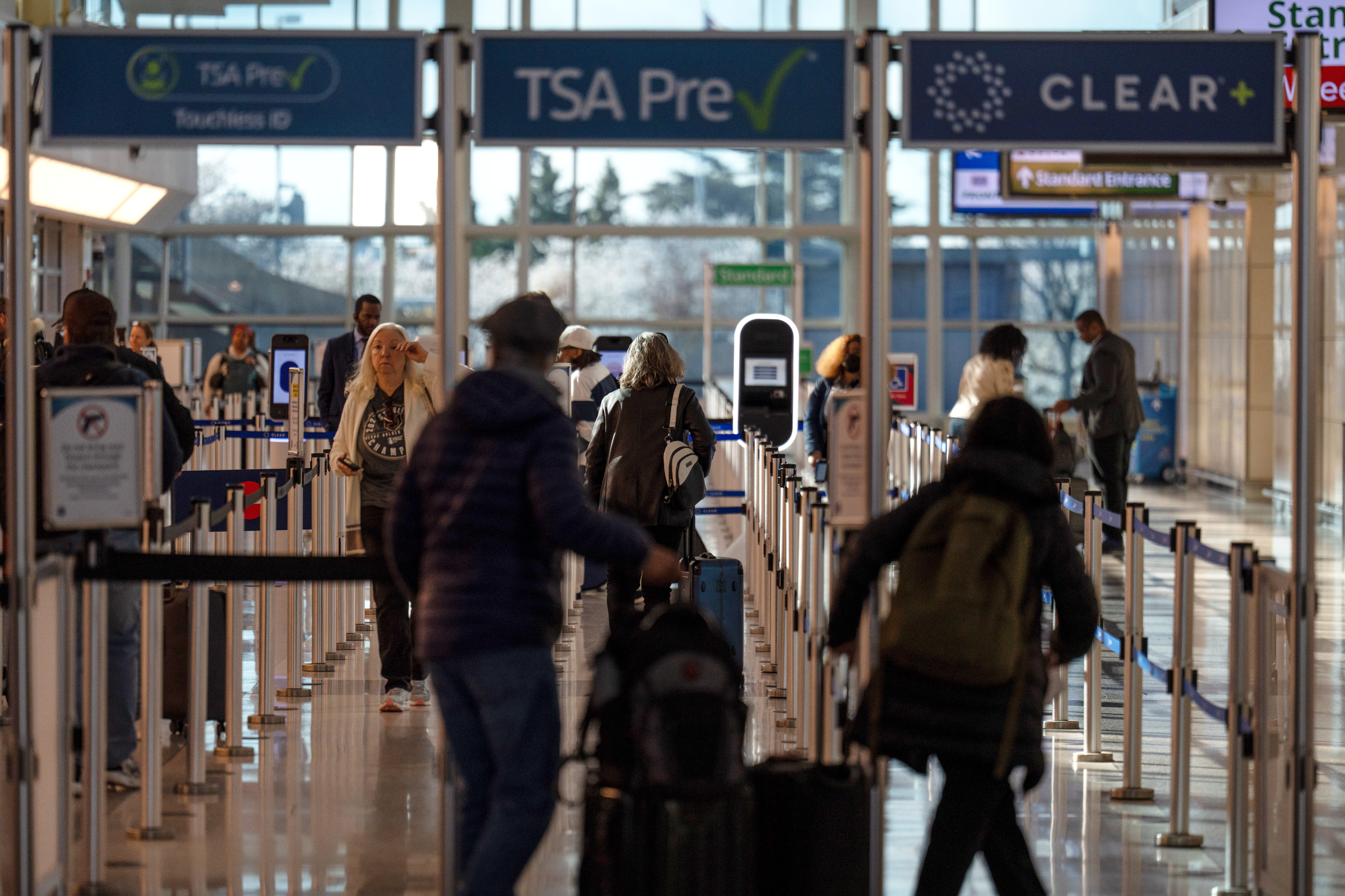 FILE - Travelers walk through a TSA security checkpoint at Reagan National Airport in Washington,  March 24, 2026.